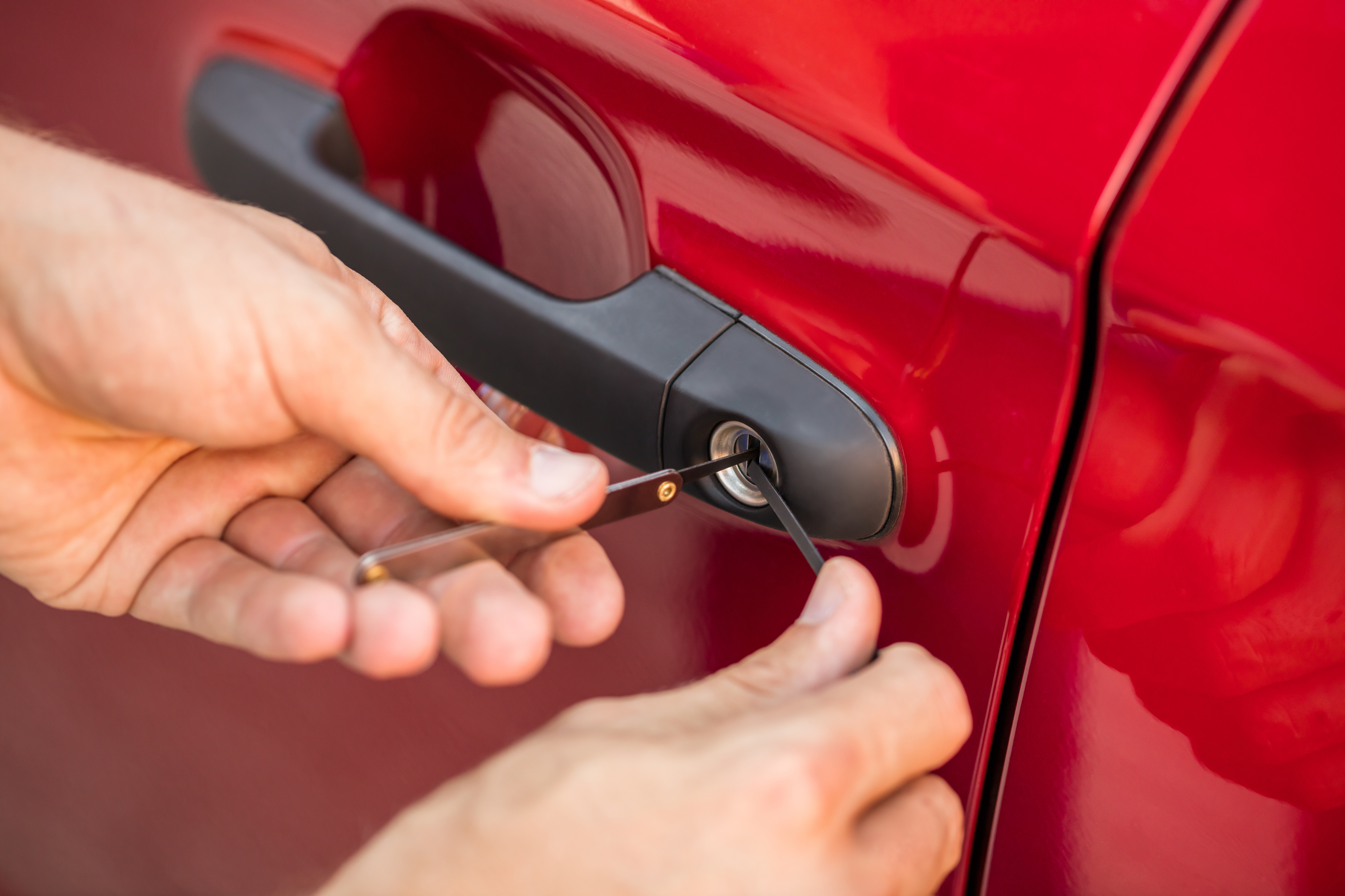 Close-up Of Person's Hand Opening Car Door With Lockpicker